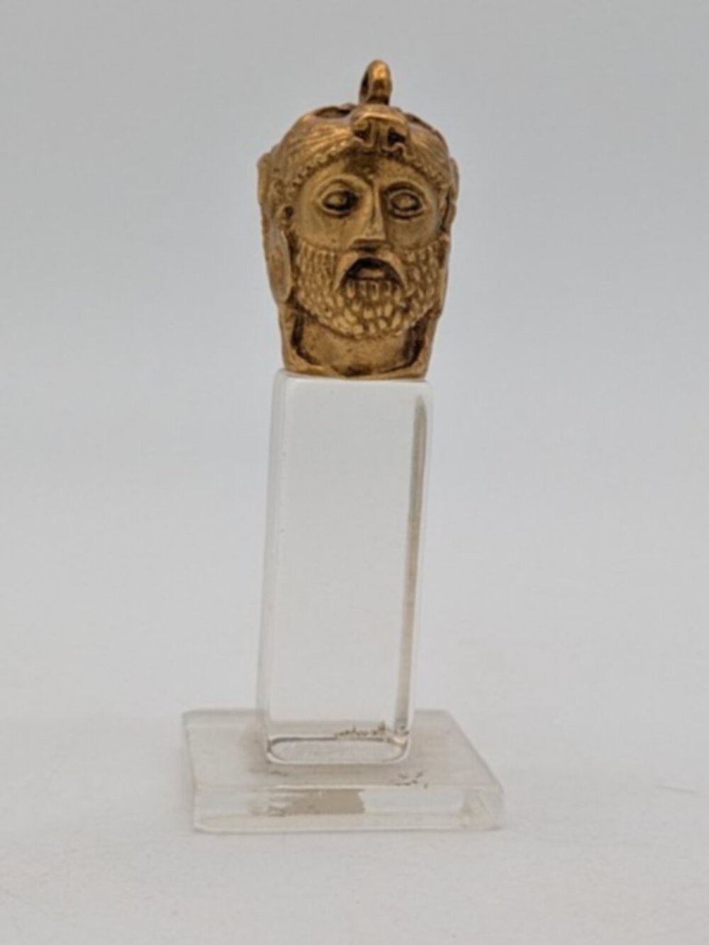 Alva repo gold tone pendant in shape Heracles head on lucite or acrylic pedestal